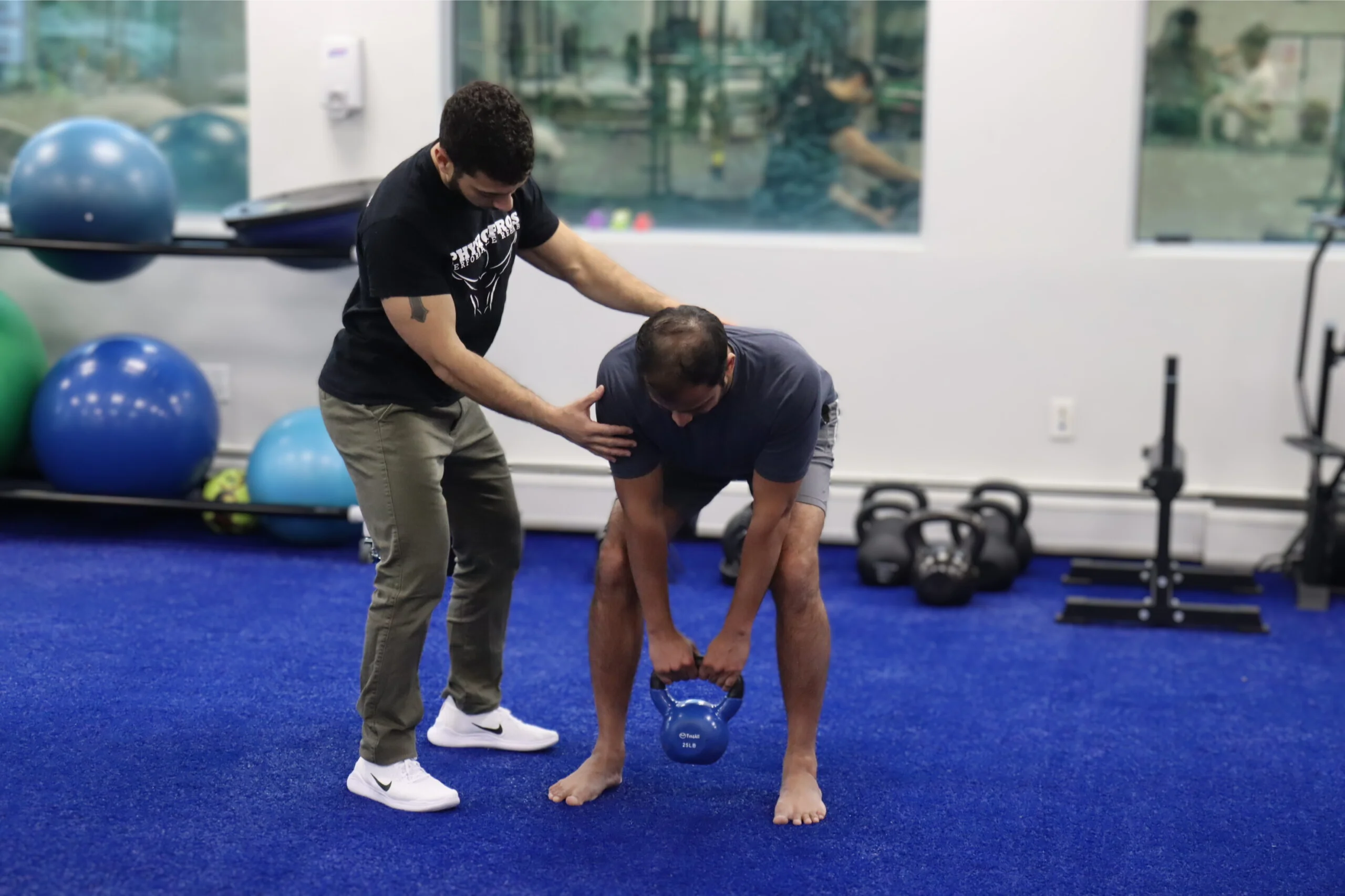 PT demonstrating KB Deadlifts to patients